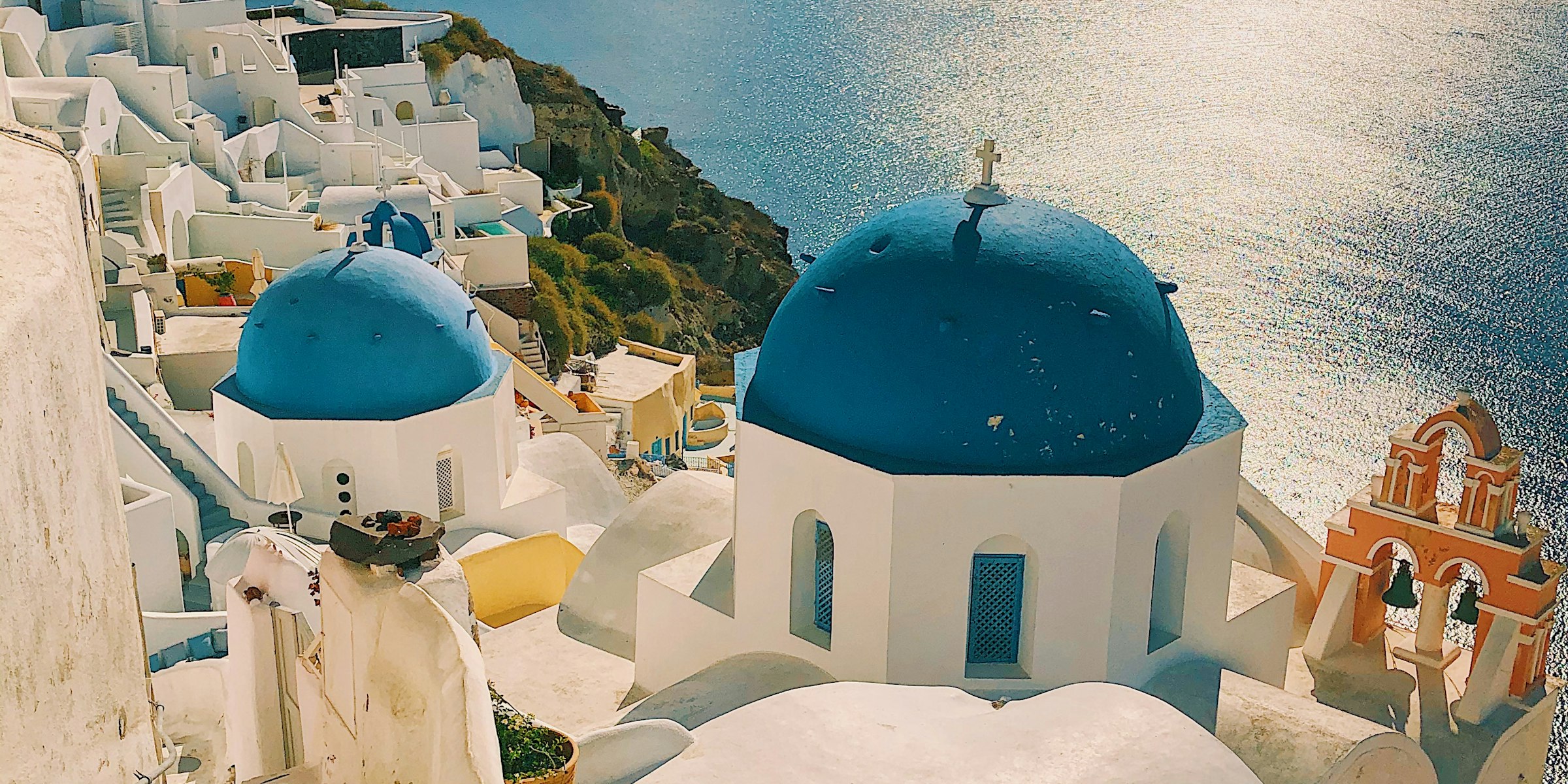 Whitewashed cliffside village above a deep-blue sea